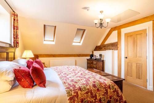 a bedroom with a large white bed with red pillows at The Town House Ludlow in Ludlow