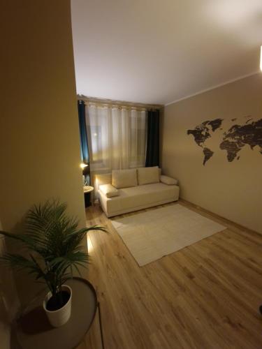 salon z białą kanapą i mapą świata na ścianie w obiekcie 91WrocLove Apartaments we Wrocławiu