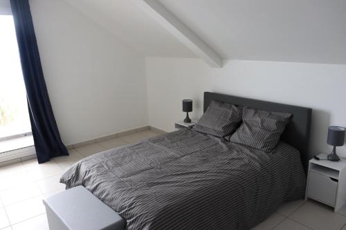 a bedroom with a bed and two night stands and a window at Le Sandivel in Saint-Denis