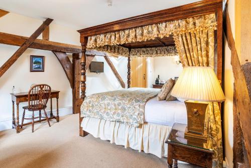 a bedroom with a canopy bed and a desk at The Town House Ludlow in Ludlow