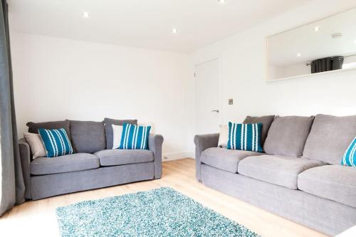 a living room with two gray couches and a rug at The Spitfire - Renovated 3-bed house in Cheltenham, SLEEPS 8 in Cheltenham