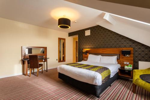 um quarto de hotel com uma cama e uma secretária em Holiday Inn Newcastle-Jesmond, an IHG Hotel em Newcastle upon Tyne