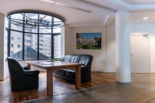 ein Wohnzimmer mit einem Tisch und 2 Stühlen in der Unterkunft Center Hotel in Tallinn