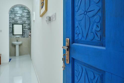 a blue door in a bathroom with a sink at Salem Fish Guest House in Al Ḩadd