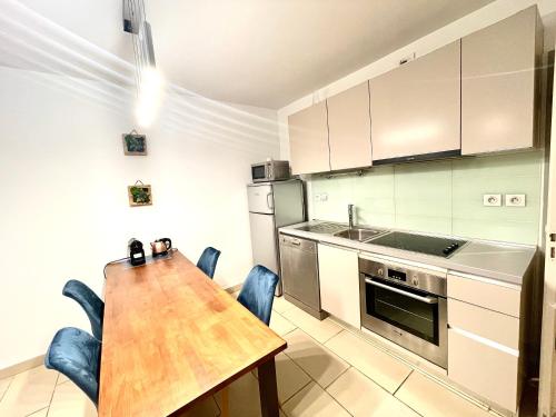 - une cuisine avec une table et des chaises en bois dans l'établissement Jolie 3 pièces avec terrasse au vieux port, à 2 pas des plages et du palais., à Cannes