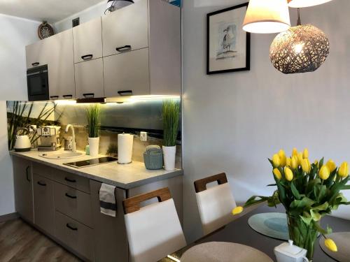 ブワディスワボボにあるApartament Elieのキッチン(シンク、黄色のチューリップ付きのテーブル付)