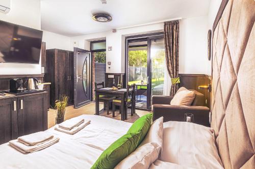 um quarto com uma cama, uma televisão e um sofá em Park Hotel Bük-Bükfürdő em Bük