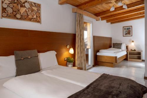 una camera con un letto e una camera con un letto e una finestra di A. Paolo Apartments a Vigo di Fassa