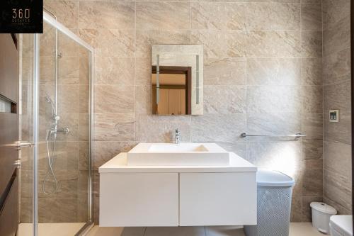 een badkamer met een witte wastafel en een spiegel bij Seafront, Designer APT with Private Terrace & WIFI by 360 Estates in Tal-Pietà