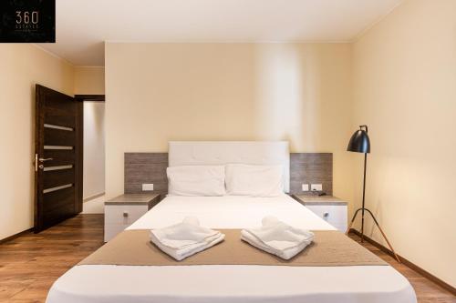 een slaapkamer met een groot wit bed en 2 handdoeken bij Seafront, Designer APT with Private Terrace & WIFI by 360 Estates in Tal-Pietà