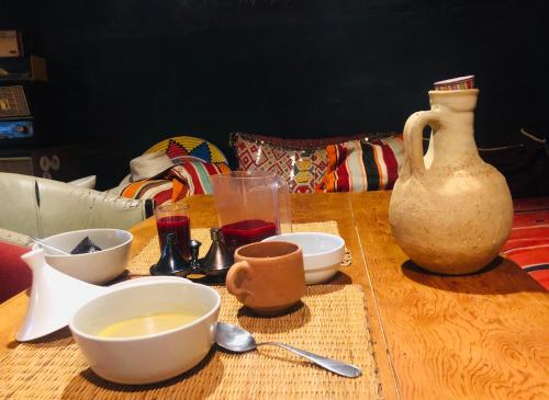 a table with bowls and cups and a vase on it at Maison d'Hôtes Irocha in Tisselday