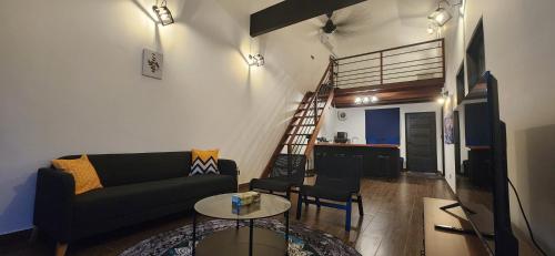 uma sala de estar com um sofá e uma mesa em Kamalia Villas em Kampung Penarik
