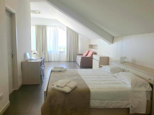 a bedroom with a large bed with two towels on it at Hotel Grel in Chiaramonte Gulfi