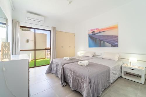 a bedroom with a bed and a large window at Villa Magna - Apt- 206 by HelloVacations in Albufeira