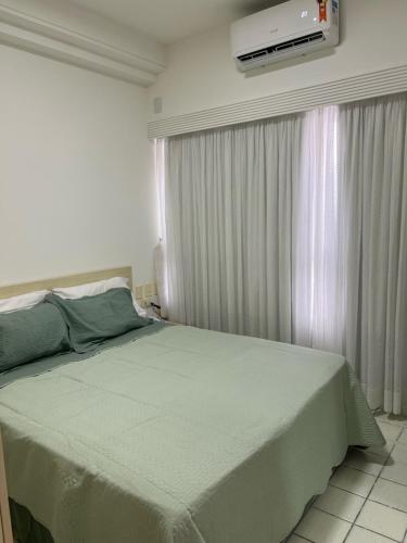 a bedroom with a large bed with a tv on the wall at Flat - Navegantes Residence Hotel in Recife
