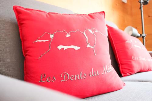 a red pillow with the words les detritus au mic at Chalet La Pala avec SPA in Val dʼIlliez