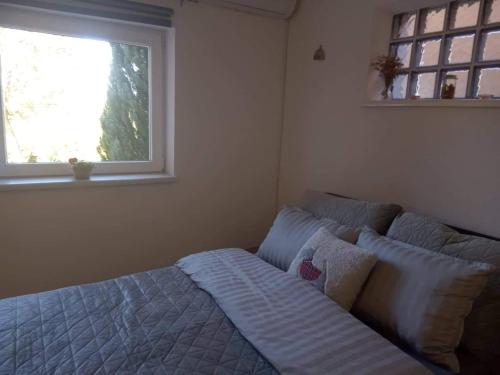 a bed in a bedroom with a window at CHEZ Marthe, Organic Farm stay in Knin