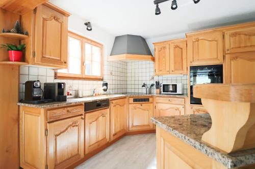 a kitchen with wooden cabinets and granite counter tops at Chalet La Pala avec SPA in Val dʼIlliez