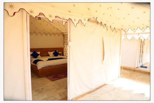 a bedroom with a canopy bed and a bedroom with a window at Marina Dessert Camp in Sām