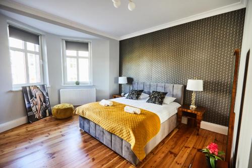 a bedroom with a bed with a yellow blanket on it at Art Deco Apartament dla 6 osób Chorzów/Katowice 6B in Chorzów