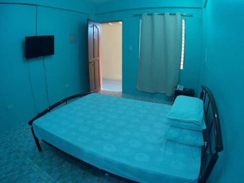 um quarto azul com uma cama e uma janela em Cebu Leisure Lodge em Cebu