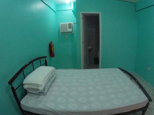 a bed in a room with a blue wall at Cebu Leisure Lodge in Cebu City