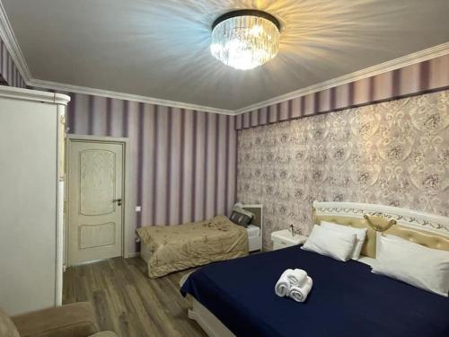 a bedroom with a blue bed and a couch at Park Azure Modern apartment in Baku