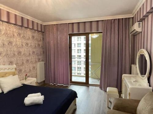 Schlafzimmer mit einem Bett, einer Badewanne und einem Spiegel in der Unterkunft Park Azure Modern apartment in Baku