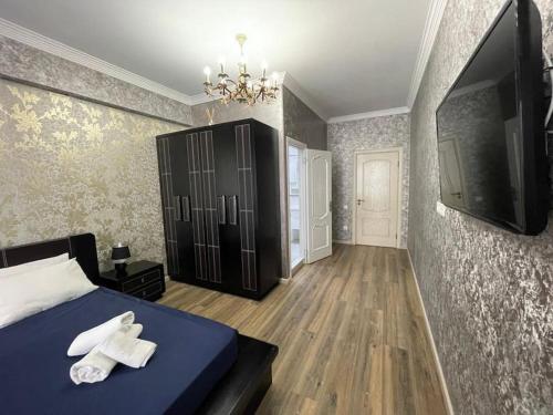 a bedroom with a bed with two towels on it at Park Azure Modern apartment in Baku