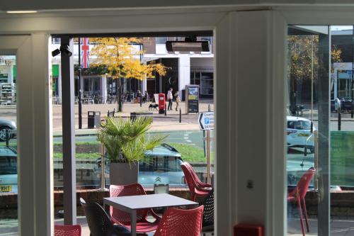 a table and chairs in front of a store window at Holiday Inn Kenilworth - Warwick by IHG in Kenilworth