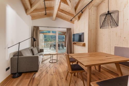a living room with a table and a couch at Apartmentresort MyLodge in Schladming