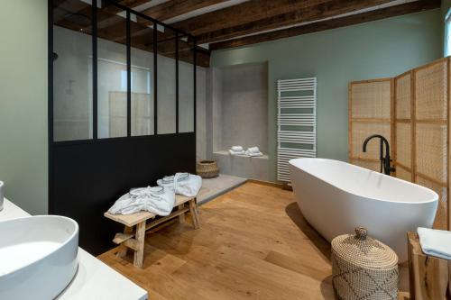 a bathroom with a large tub and two sinks at Martin's Relais in Bruges