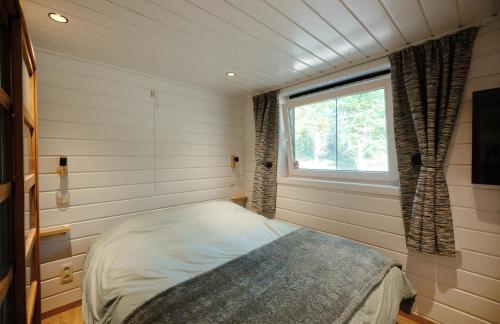 um pequeno quarto com uma cama e uma janela em Chalet D'un Ami em Somme-Leuze