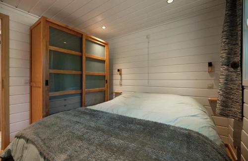um pequeno quarto com uma cama no canto em Chalet D'un Ami em Somme-Leuze