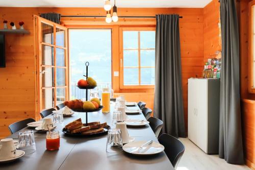 a long table in a room with a large window at Chalet La Pala in Val-d'Illiez