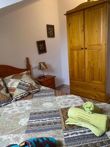 a bedroom with two beds and a wooden cabinet at Marisa Mored vivienda de uso Turistico in Laspaúles