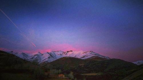 a sunset over a snow covered mountain range at Marisa Mored vivienda de uso Turistico in Laspaúles