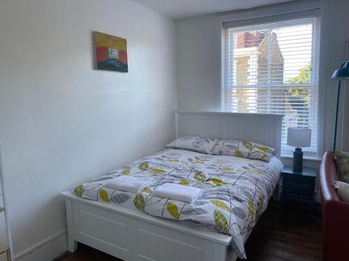 1 dormitorio con cama con edredón y ventana en Accommodation HUB Studio 2, en Londres