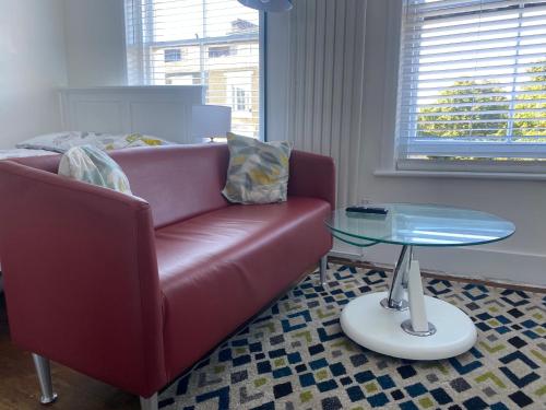 sala de estar con sofá rojo y mesa de cristal en Accommodation HUB Studio 2, en Londres