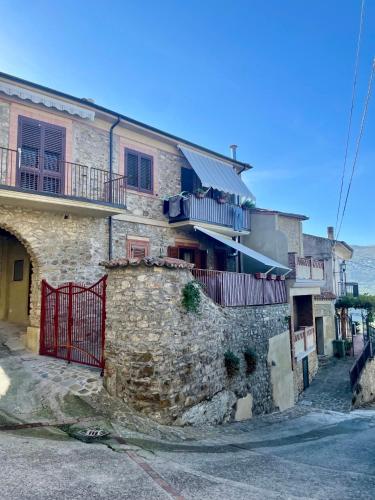 a stone house with a gate and a stone wall at La Casa del Nonno in Torchiara