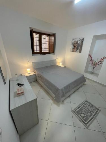 a white bedroom with a bed and a window at La Casa del Nonno in Torchiara