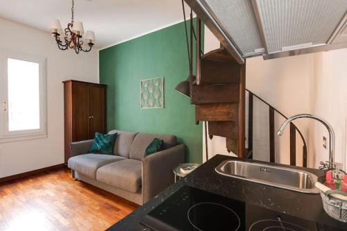 kuchnia i salon z kanapą i umywalką w obiekcie In Piazza 'Apartments & Relax' w Rawennie