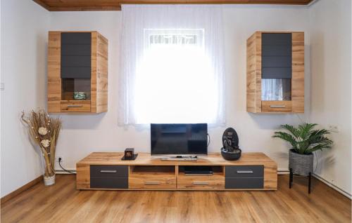 LoichにあるRuhige Ferienwohnung Loichのリビングルーム(木製キャビネット内のテレビ付)