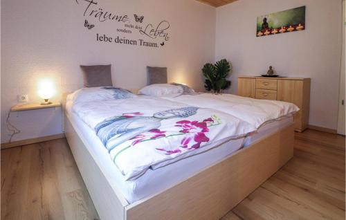 a bedroom with a large white bed with flowers on it at Beautiful Apartment In Loich With Wifi in Loich