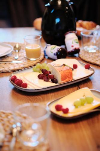 a table with two plates of food and glasses of wine at Genieterke in Somme-Leuze