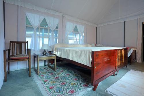 a bedroom with a bed and a table and a chair at Devi Villa - Plantation Retreat and Forest Getaway in Kutta