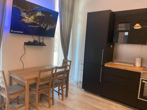 a dining room with a table and a tv on a wall at Apartment Vitosha vu Sofia in Sofia