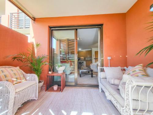 un soggiorno con pareti arancioni e mobili bianchi di MEDANO4YOU La Terraza De Isa a La Tejita