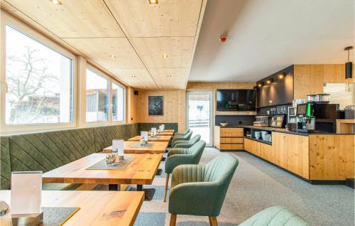 un restaurant avec des tables en bois et des chaises vertes dans l'établissement 1 Bedroom Nice Apartment In Zams, à Zams
