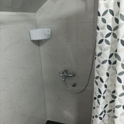 a shower in a bathroom with a shower curtain at Apartman Stan na dan in Banja Koviljača